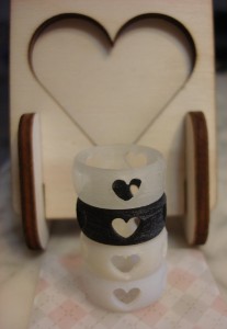 Heart Rings stacked up infront of a plywood photoframe from Ponoko